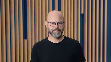 An ARRI employee in their Studio with wooden-blue background 